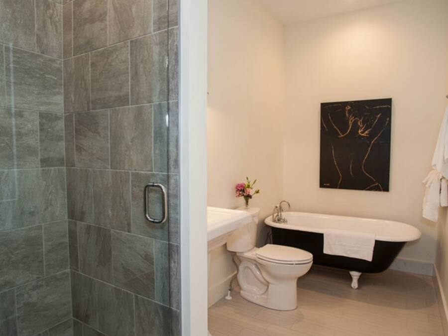 Une salle de bain avec douche, toilettes et baignoire.