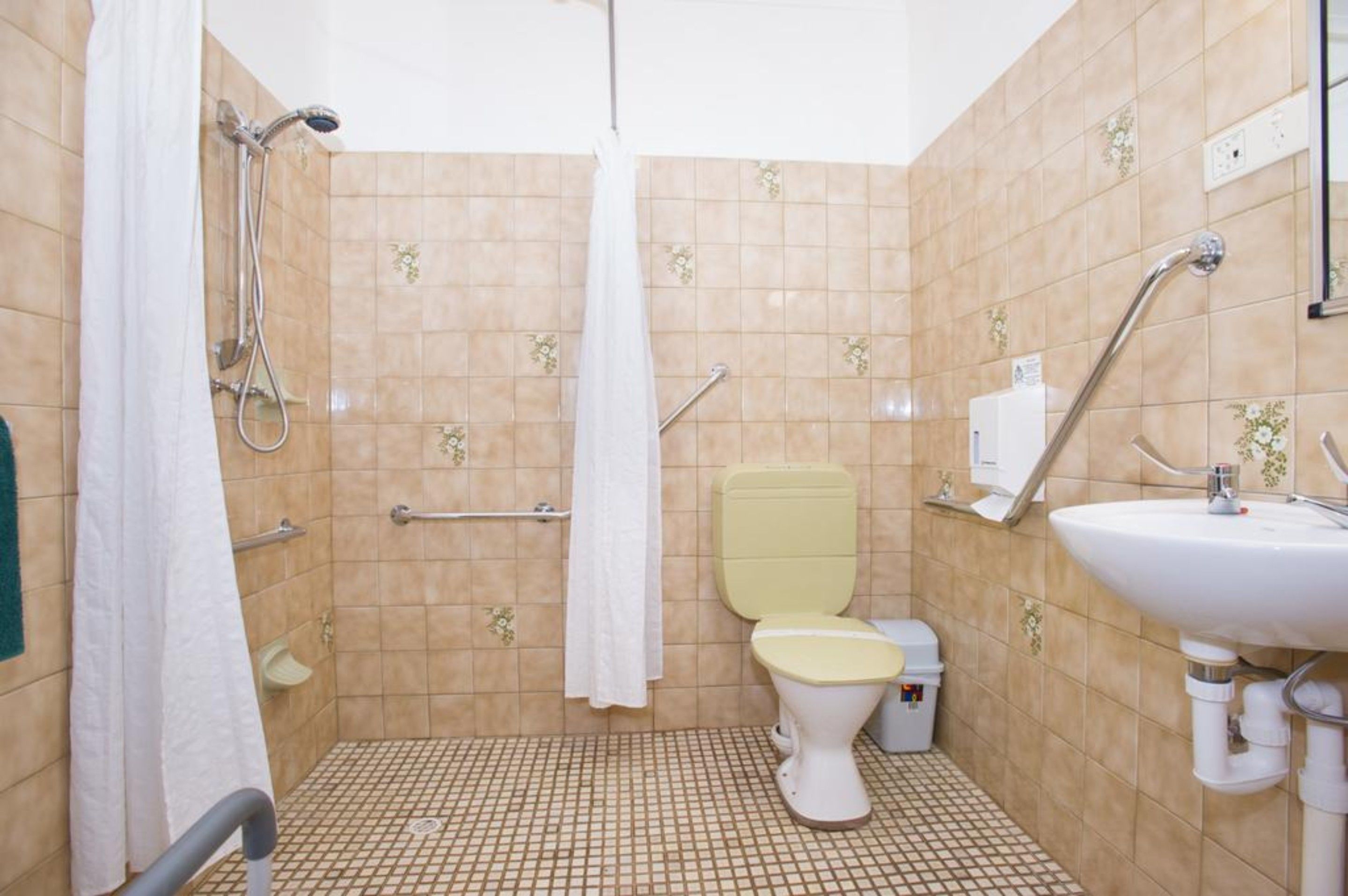 A bathroom with a shower, toilet, and sink.