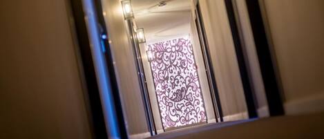 A corridor with a patterned door at the end.