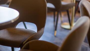 Gros plan d’une chaise avec un dossier incurvé et d’une table ronde dans un café.