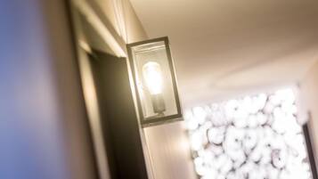 Un couloir avec un luminaire fixé au mur et un arrière-plan flou.