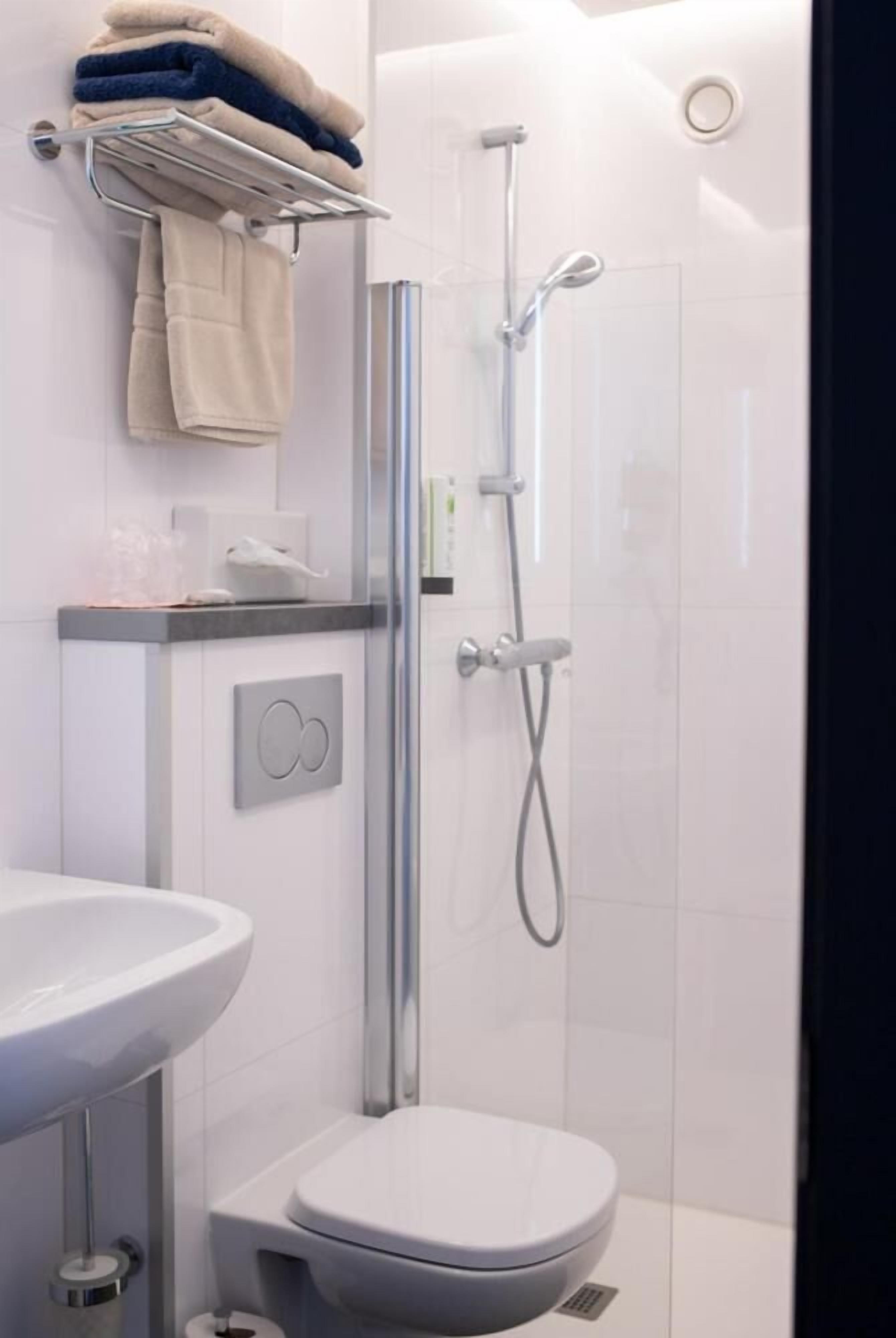 A modern bathroom with a toilet, sink, and shower.