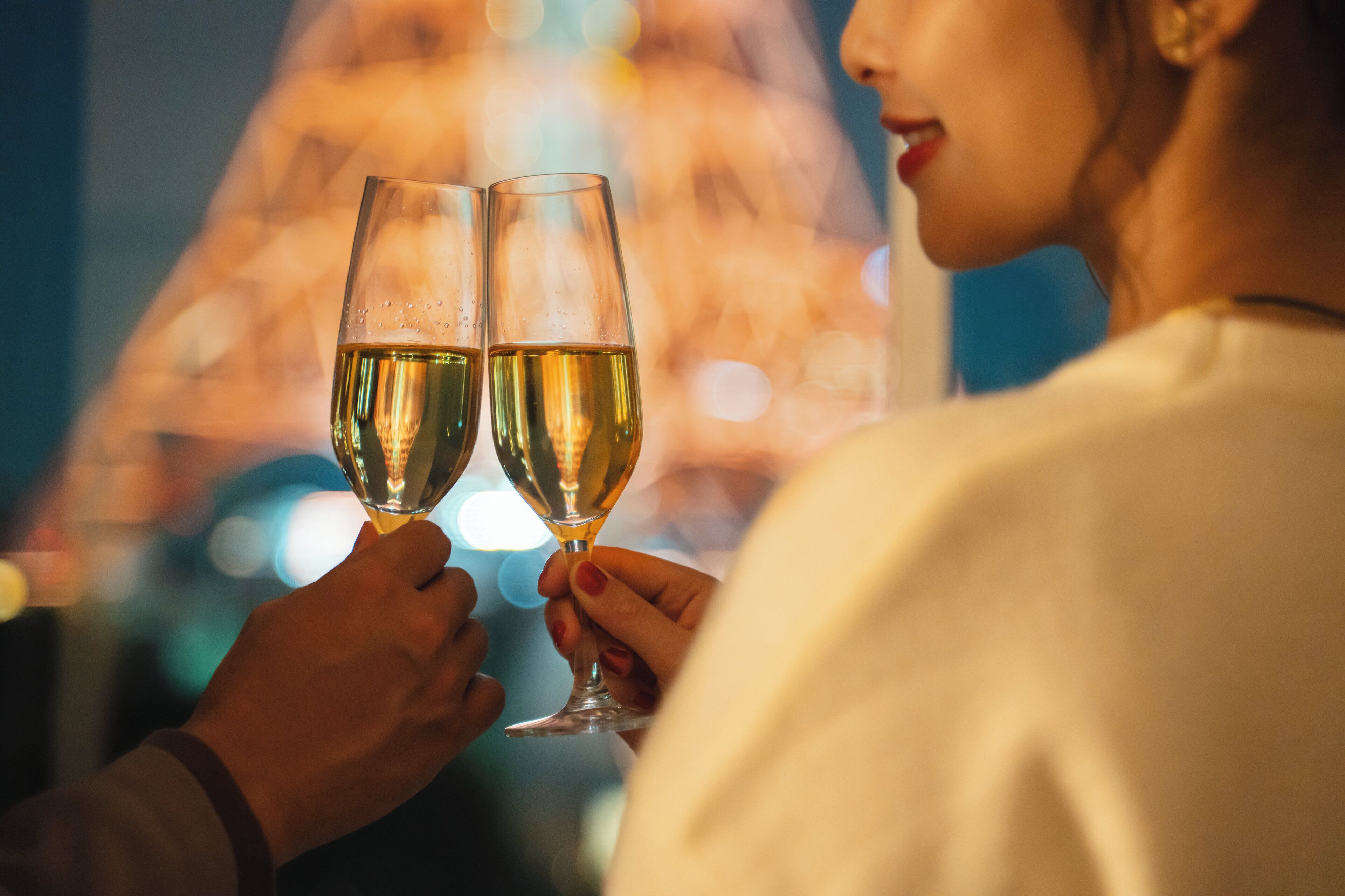 A person holding two champagne glasses.