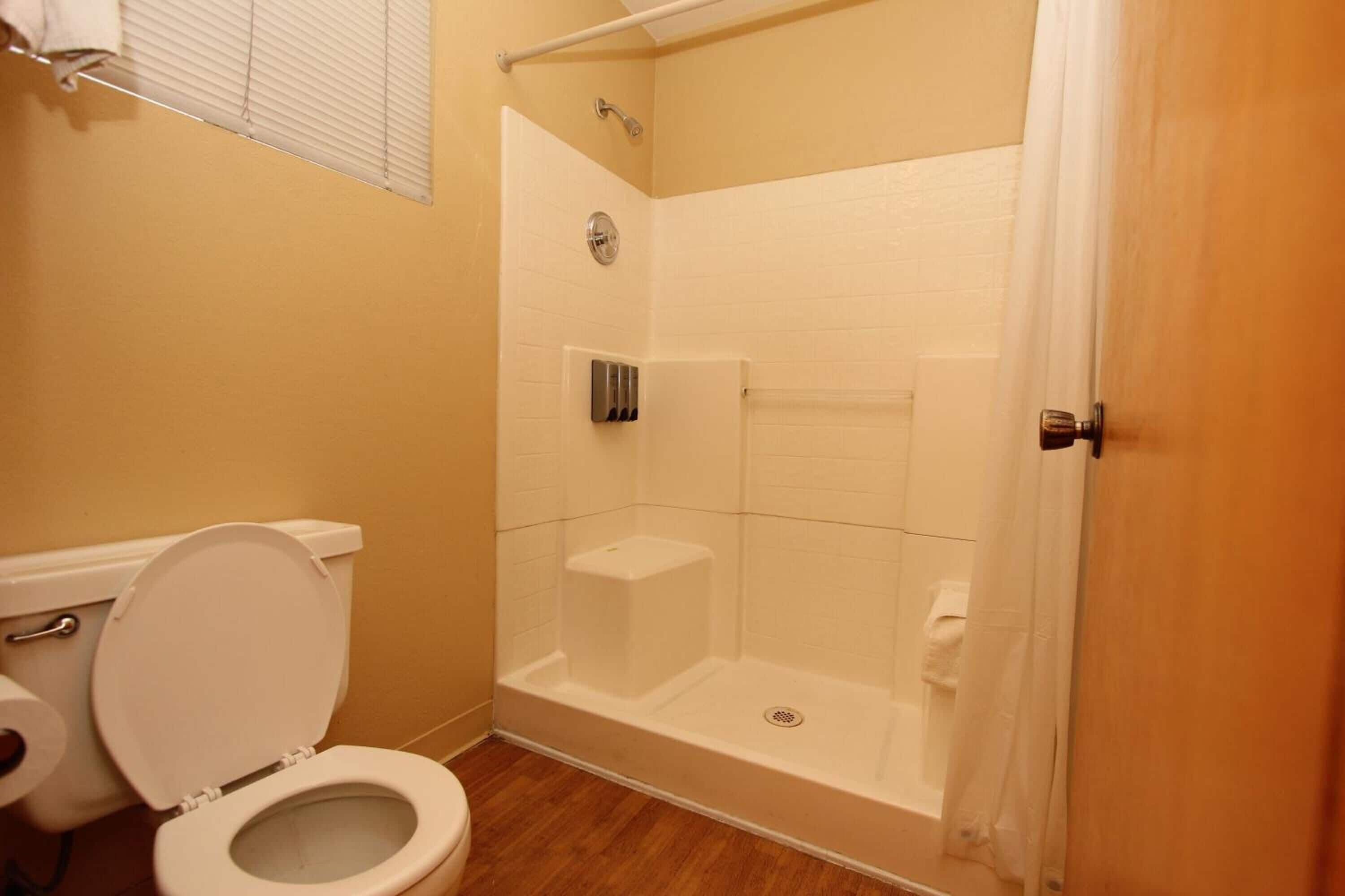 A bathroom with a toilet, a shower, and a bathtub.