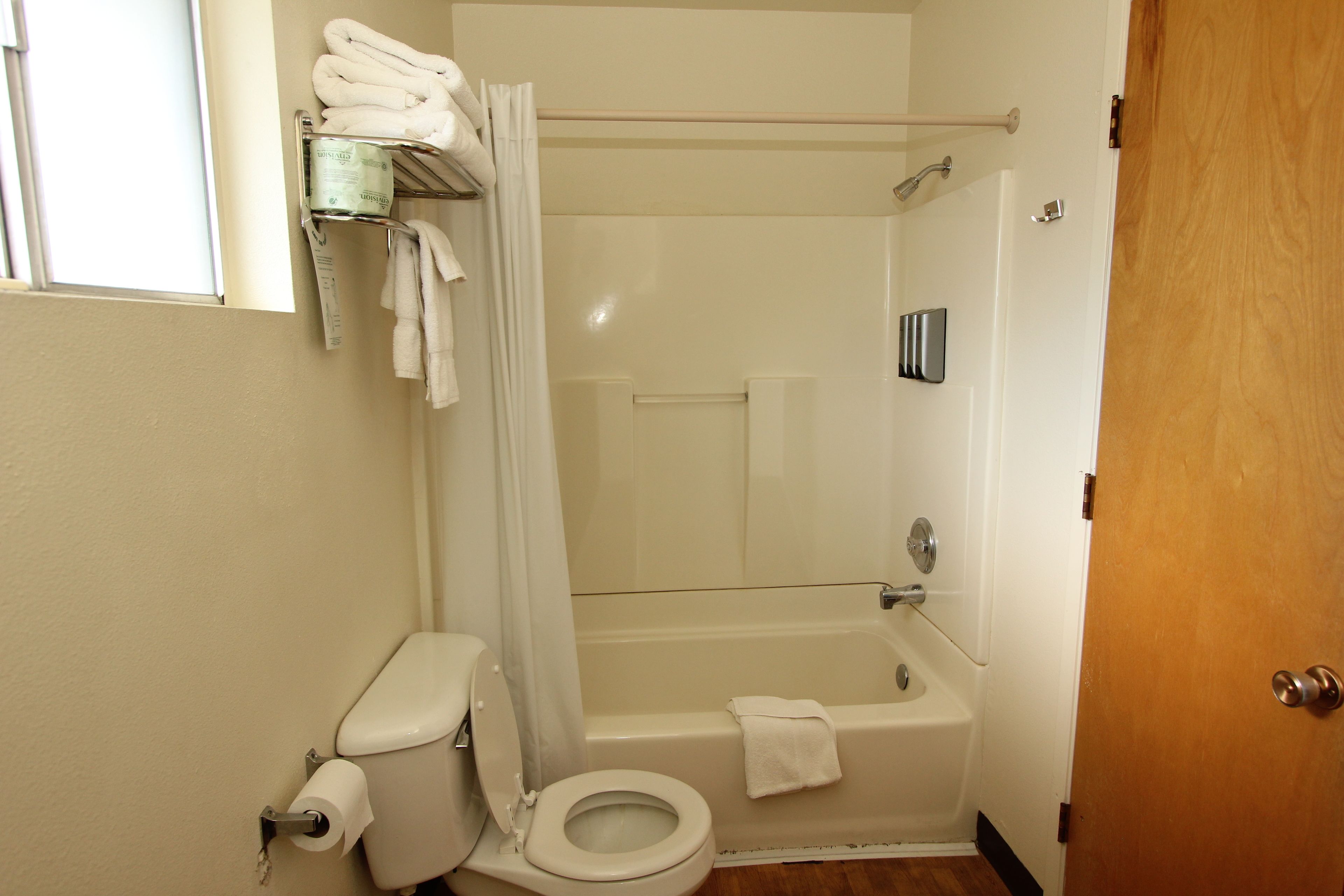 A bathroom with a toilet, a shower, and a bathtub.