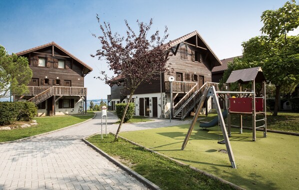 A wooden building with a balcony and a staircase leading to a second floor. - Odalys Résidence Les Chalets d'Evian (Evian-les-Bains)