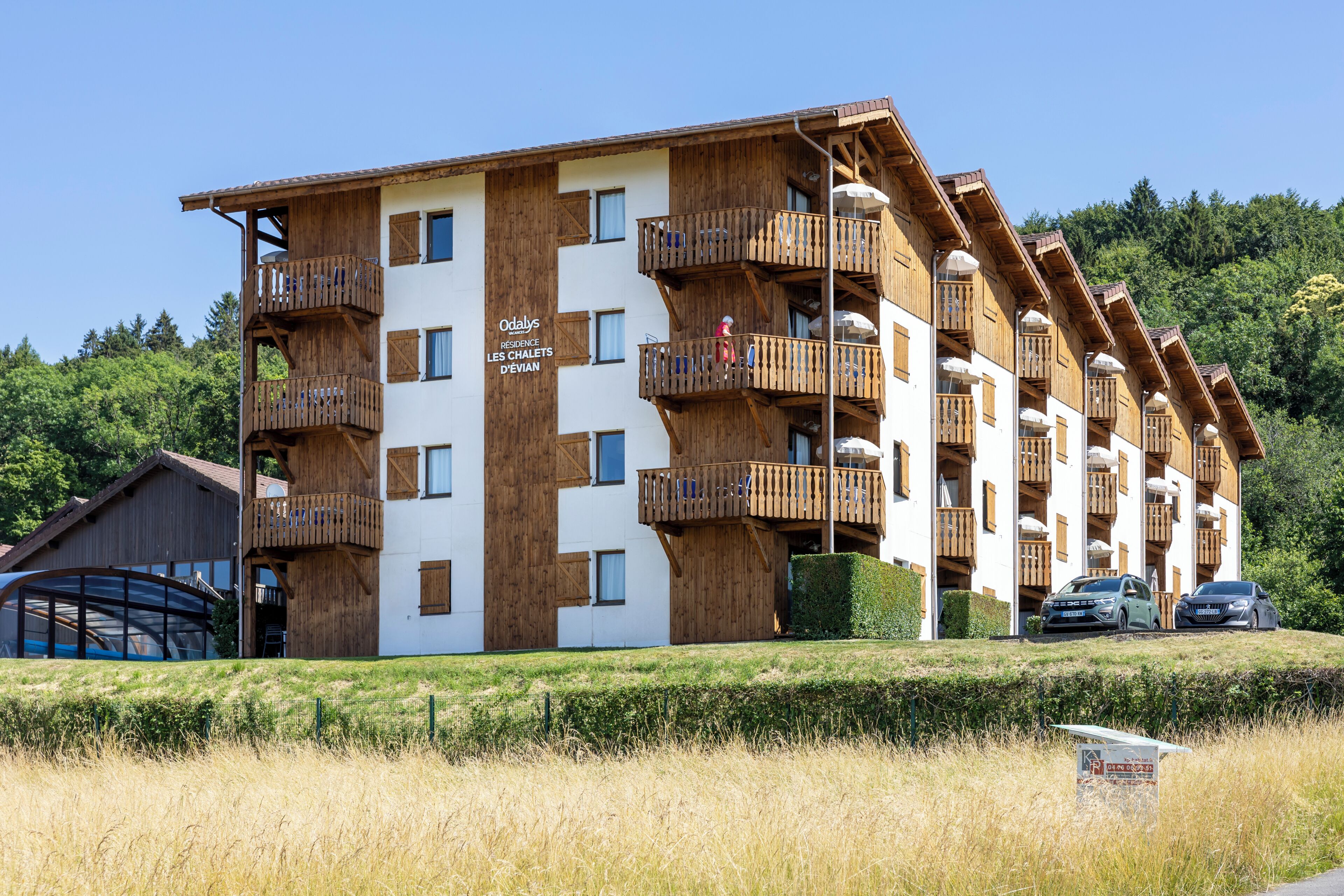 A multi-story hotel with wooden balconies and a sign indicating it is a residence.