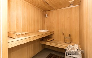 A wooden sauna with benches, a wooden bucket, and a towel rack. - Odalys Résidence Les Chalets d'Evian (Evian-les-Bains)