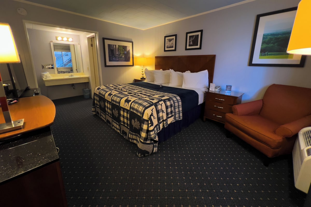 Ein Hotelzimmer mit einem Bett, einem Schreibtisch, einem Sessel und einer Kommode.