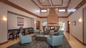A spacious lobby with a fireplace, comfortable seating, and a dining area.