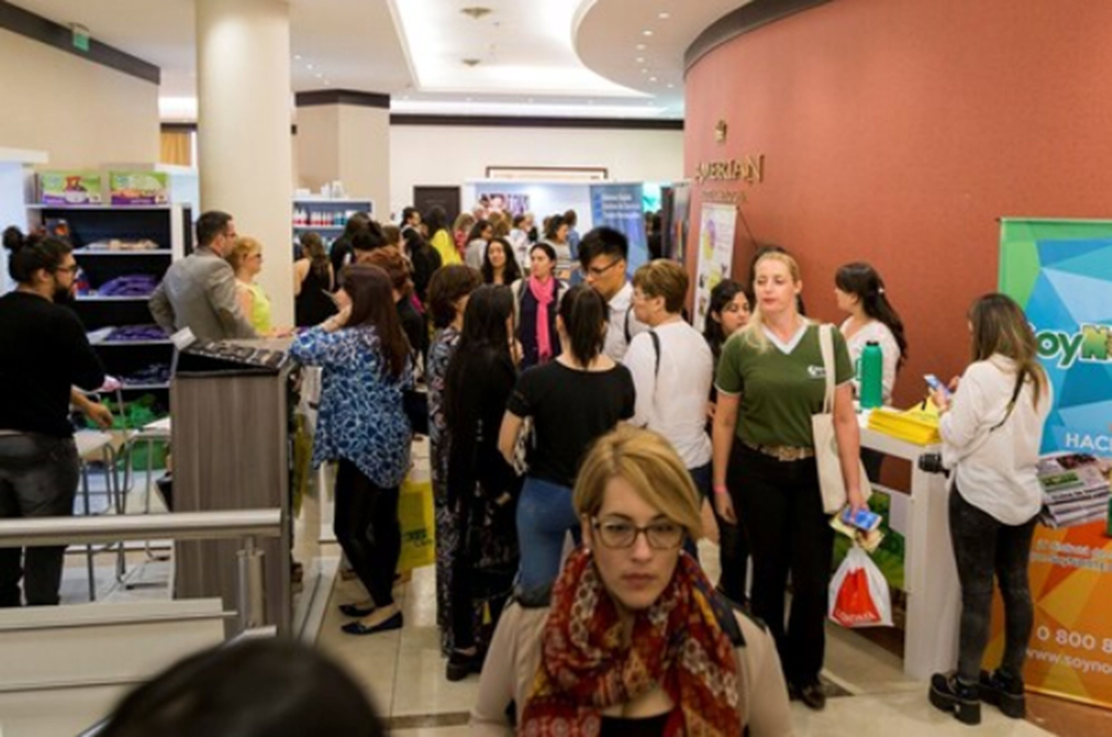 A busy indoor space with people interacting, possibly a shopping mall or event center.