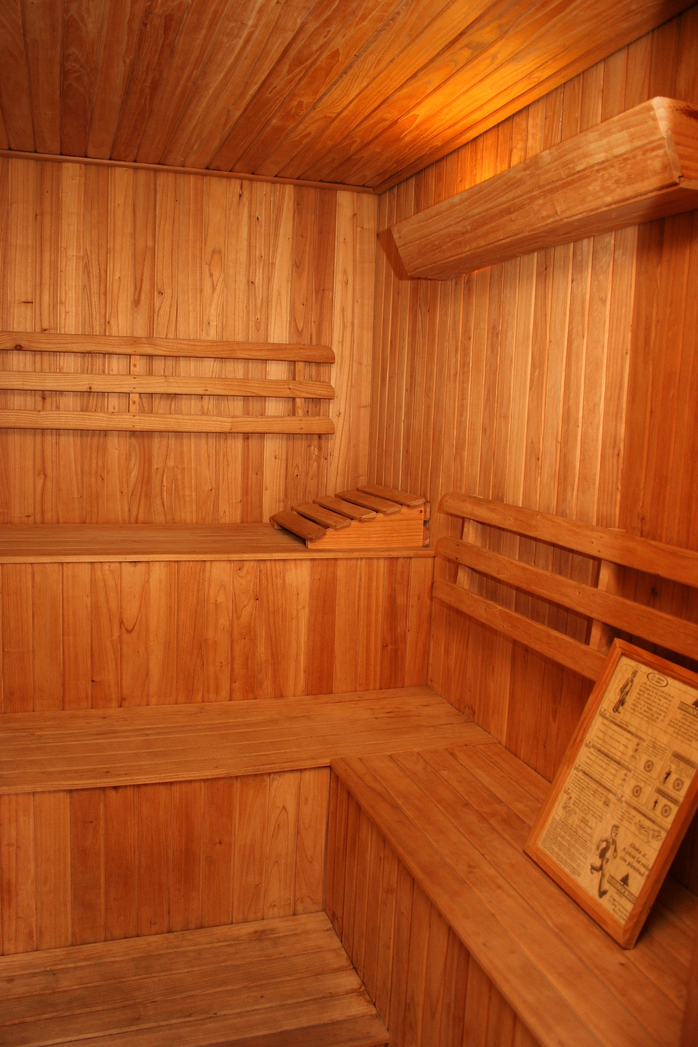 Una sauna de madera con bancos y un revestimiento de paneles de madera.