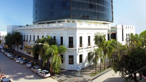 A modern building with a curved glass facade and a classical base. - Amérian Hotel Casino Gala (Resistencia)