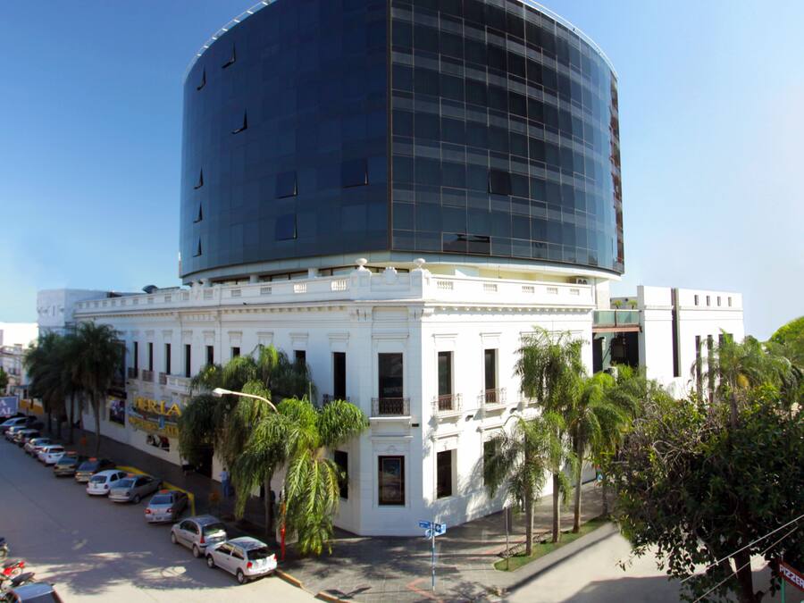A modern building with a curved glass facade and a classical base.