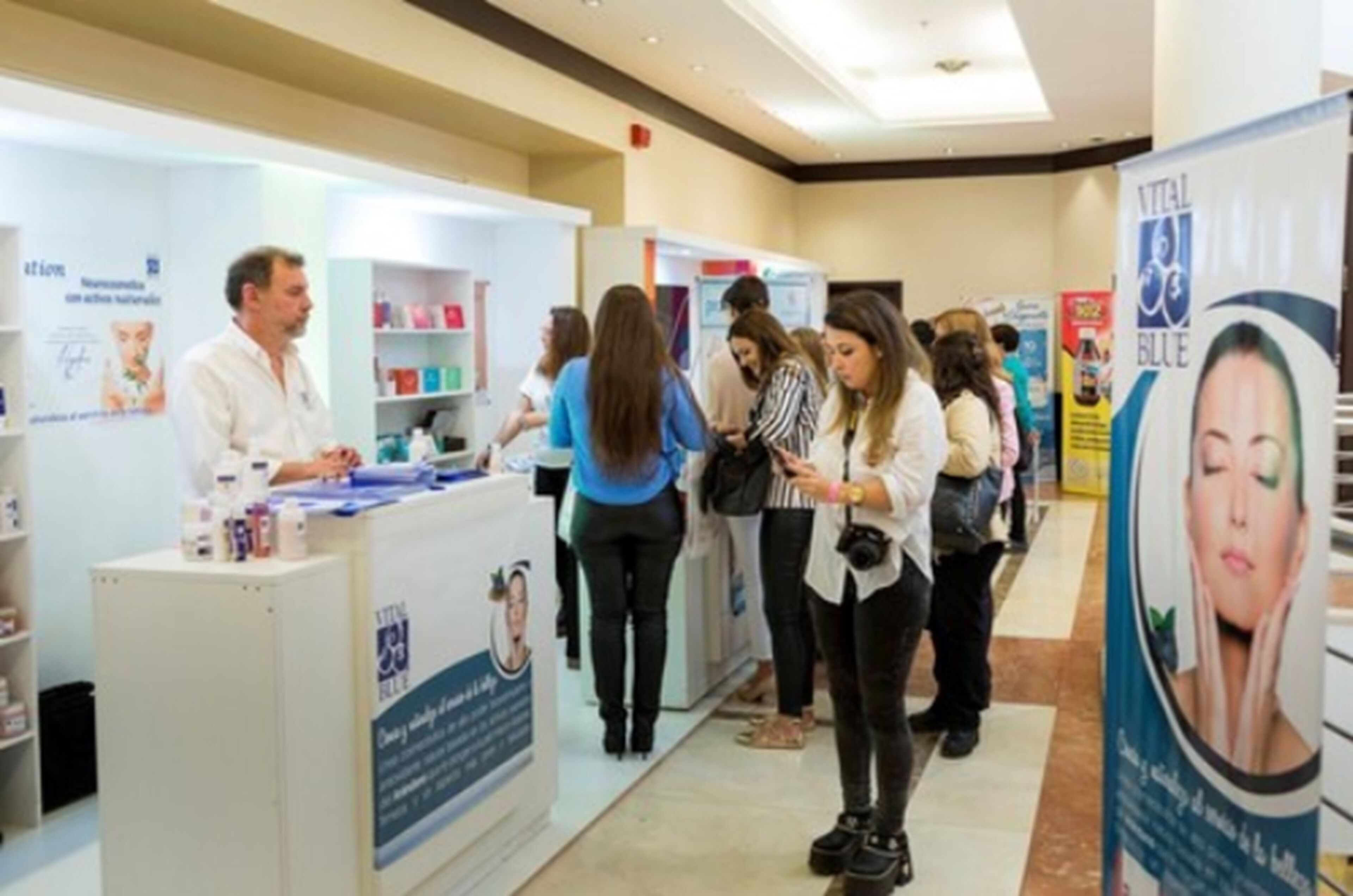 A conference or exhibition hall with attendees at booths.