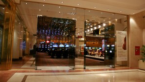 A hotel lobby with a casino area featuring slot machines and a red carpet. - Amérian Hotel Casino Gala (Resistencia)