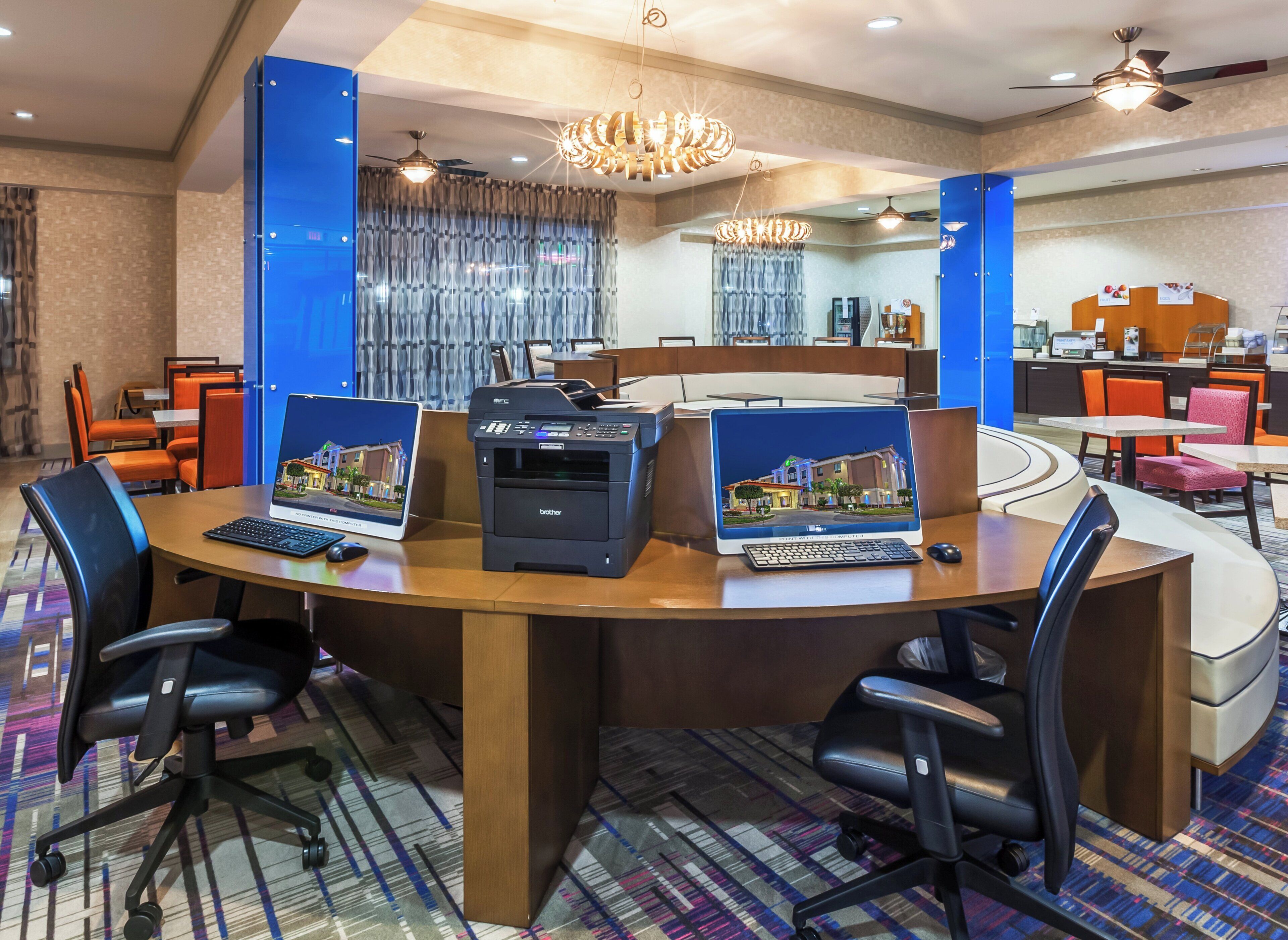 A conference room with a large table, multiple chairs, and two laptops.