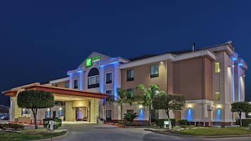 Un hôtel Holiday Inn Express doté d’une façade moderne, d’une entrée bien éclairée et d’une allée aménagée.