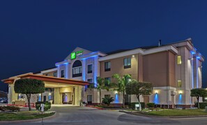 A Holiday Inn Express hotel with a modern facade, a well-lit entrance, and a landscaped driveway. - Holiday Inn Express & Suites Houston East, by IHG (Houston)