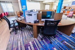 Ein moderner Arbeitsplatz mit großem Schreibtisch, mehreren Computermonitoren und Bürostühlen.