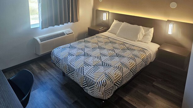 Une chambre d’hôtel comprenant un lit, des tables de chevet, un bureau et une chaise.