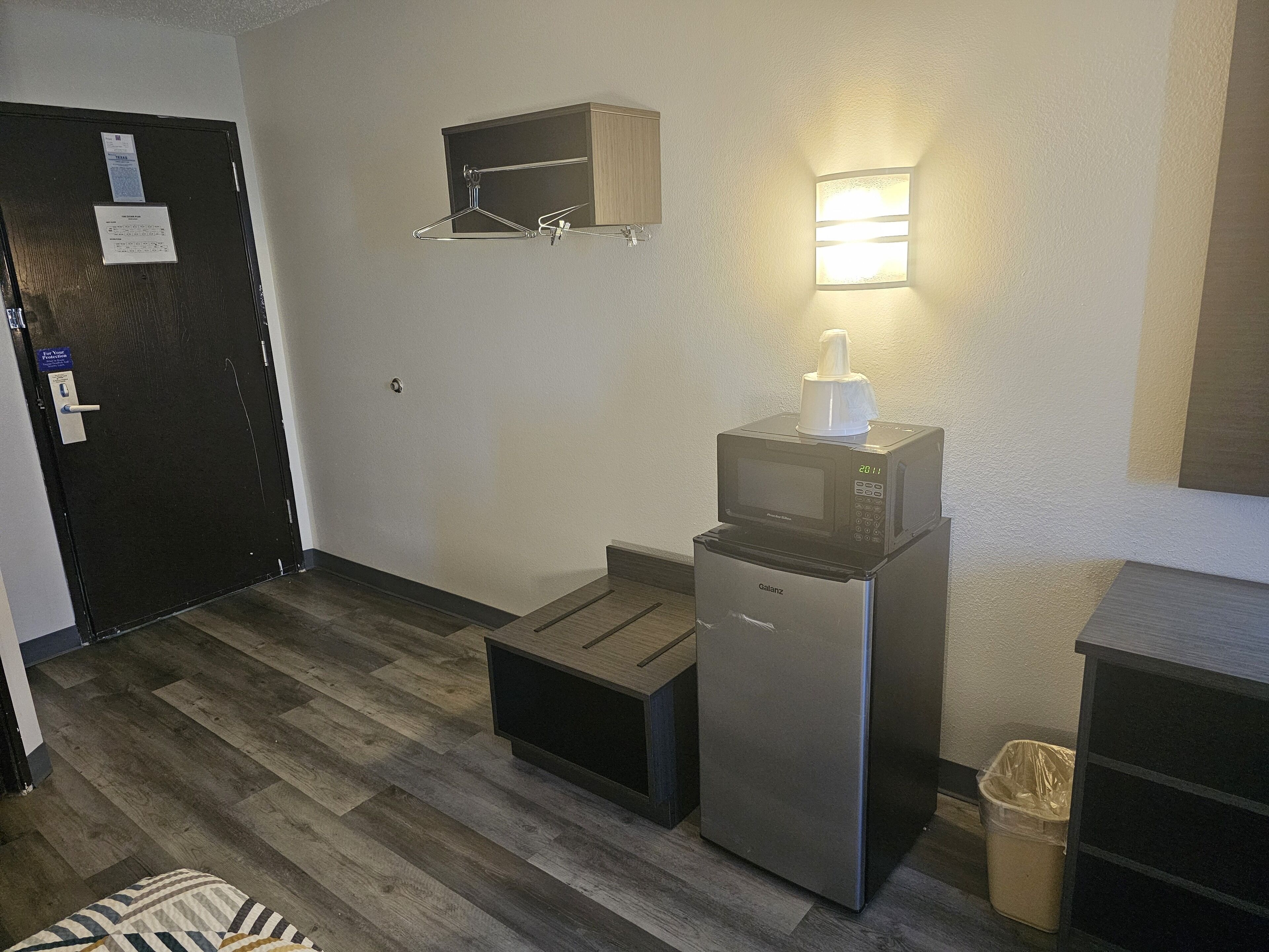 Una kitchenette compacta equipada con microondas, refrigerador y una pequeña encimera.