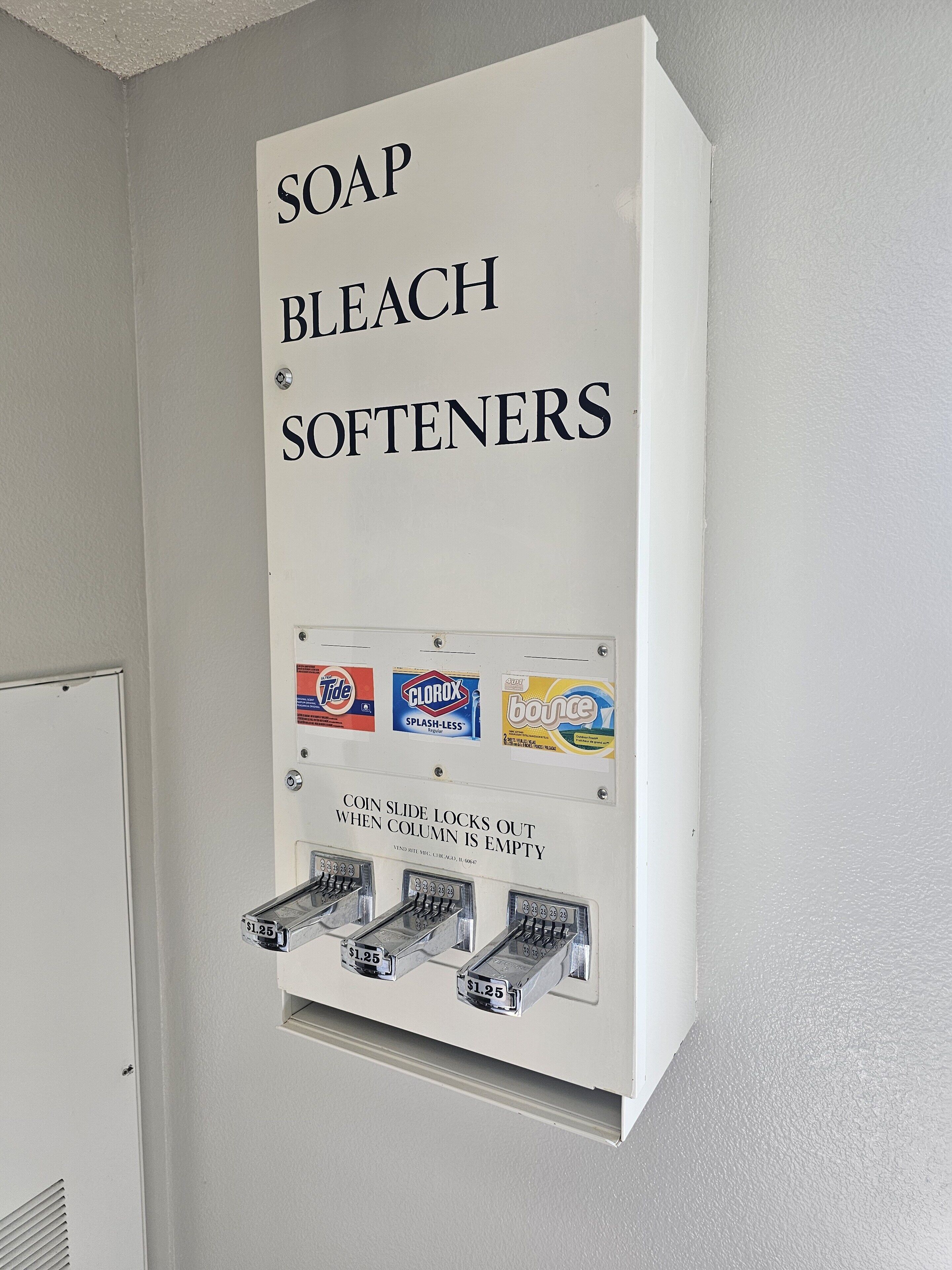 A wall-mounted dispenser with soap, bleach, and softeners.