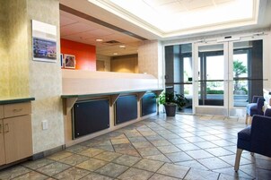 A reception area with a counter, seating, and a view through glass doors.