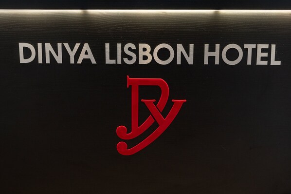 Une enseigne pour l’hôtel Dinya Lisbon, avec le nom et le logo de l’hôtel.