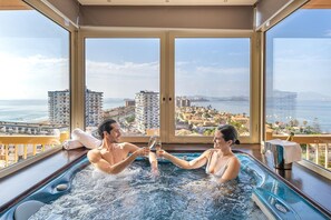 Un couple dans un jacuzzi, avec vue sur le paysage urbain.