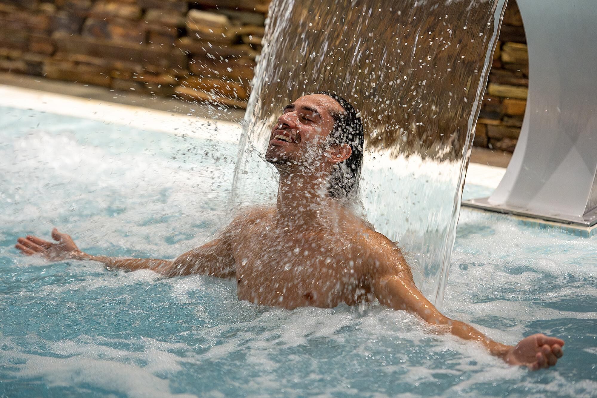 A person in a pool with water splashing around them.