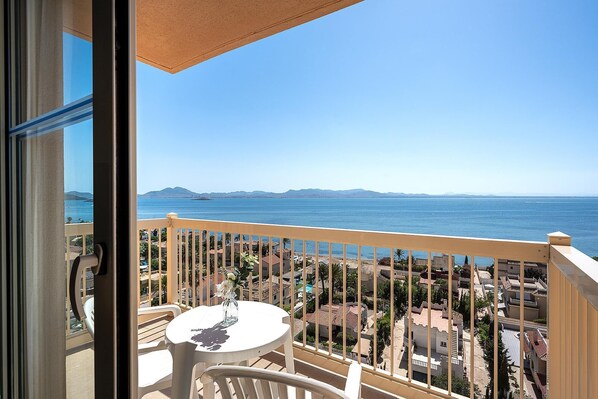 Un balcon avec vue sur la mer et les montagnes lointaines.