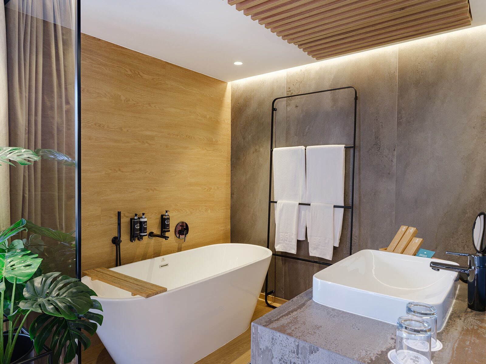 Une salle de bain moderne avec une baignoire sur pieds, un meuble-lavabo et un porte-serviettes.