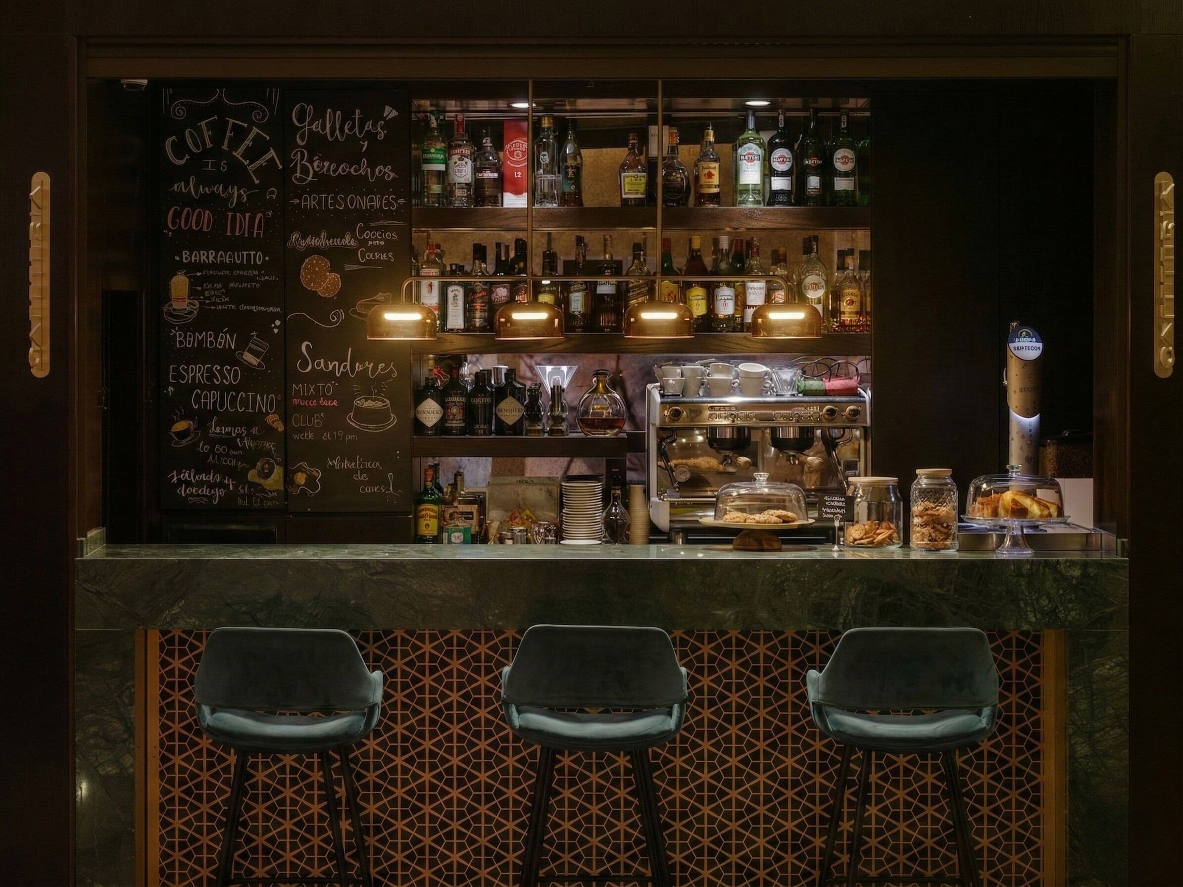 Un espace bar avec un tableau noir affichant le menu des cafés et des desserts, des étagères remplies de bouteilles d’alcool, une machine à café et des tabourets de bar.