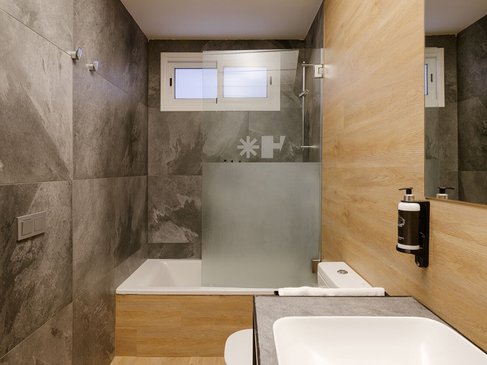 A modern bathroom with a bathtub, shower, and toilet.