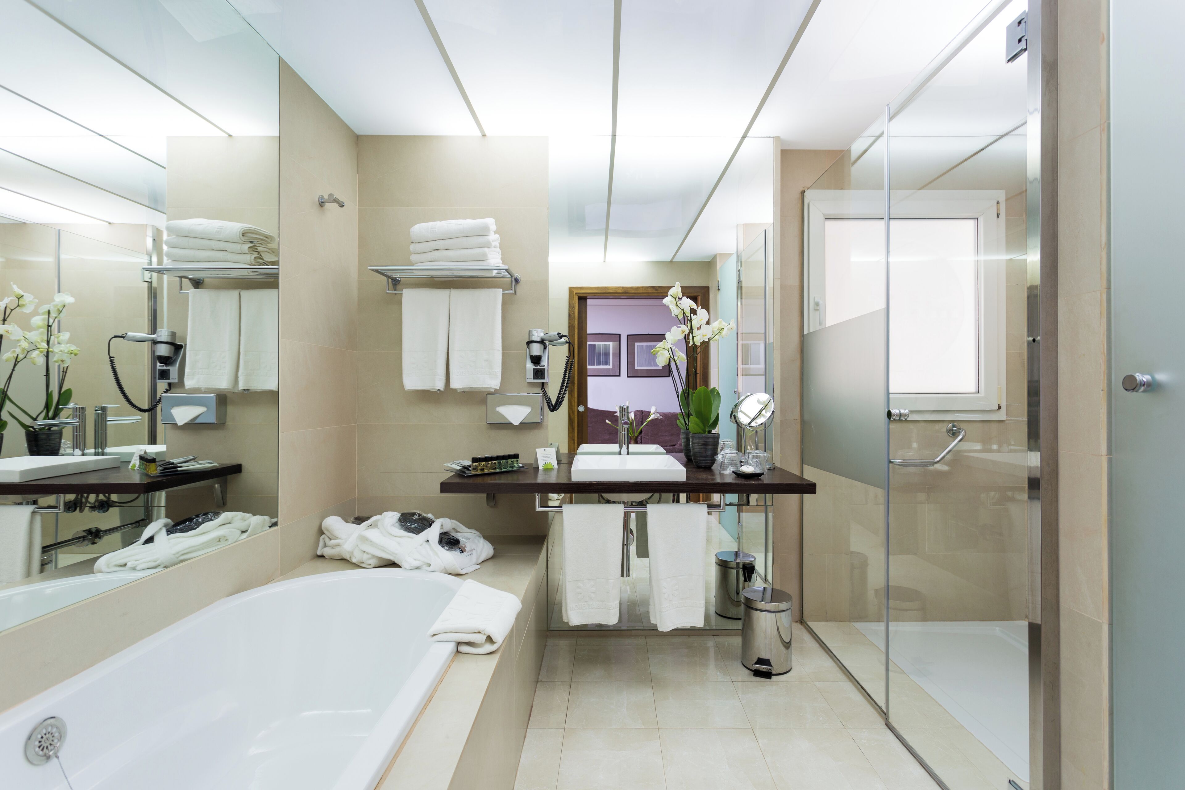 Un baño moderno con bañera, tocador con espejo y zona de ducha.