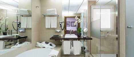 Un baño moderno con bañera, tocador con espejo y zona de ducha.