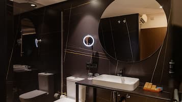 Un baño moderno con inodoro, lavamanos y espejo.