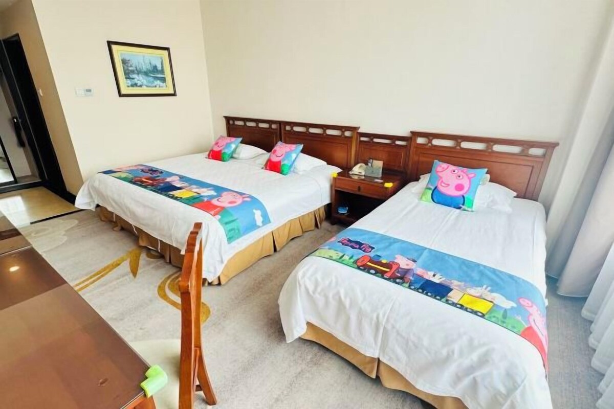 Two single beds with wooden headboards, a nightstand, and a table with chairs.