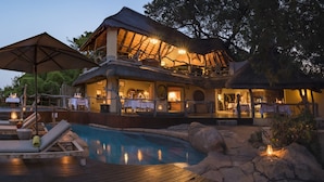A resort with a pool, outdoor seating, and a bar area. - Jock Safari Lodge (Mbombela)