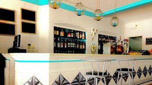 Uma área de bar com balcão, banquetas e prateleiras cheias de garrafas.