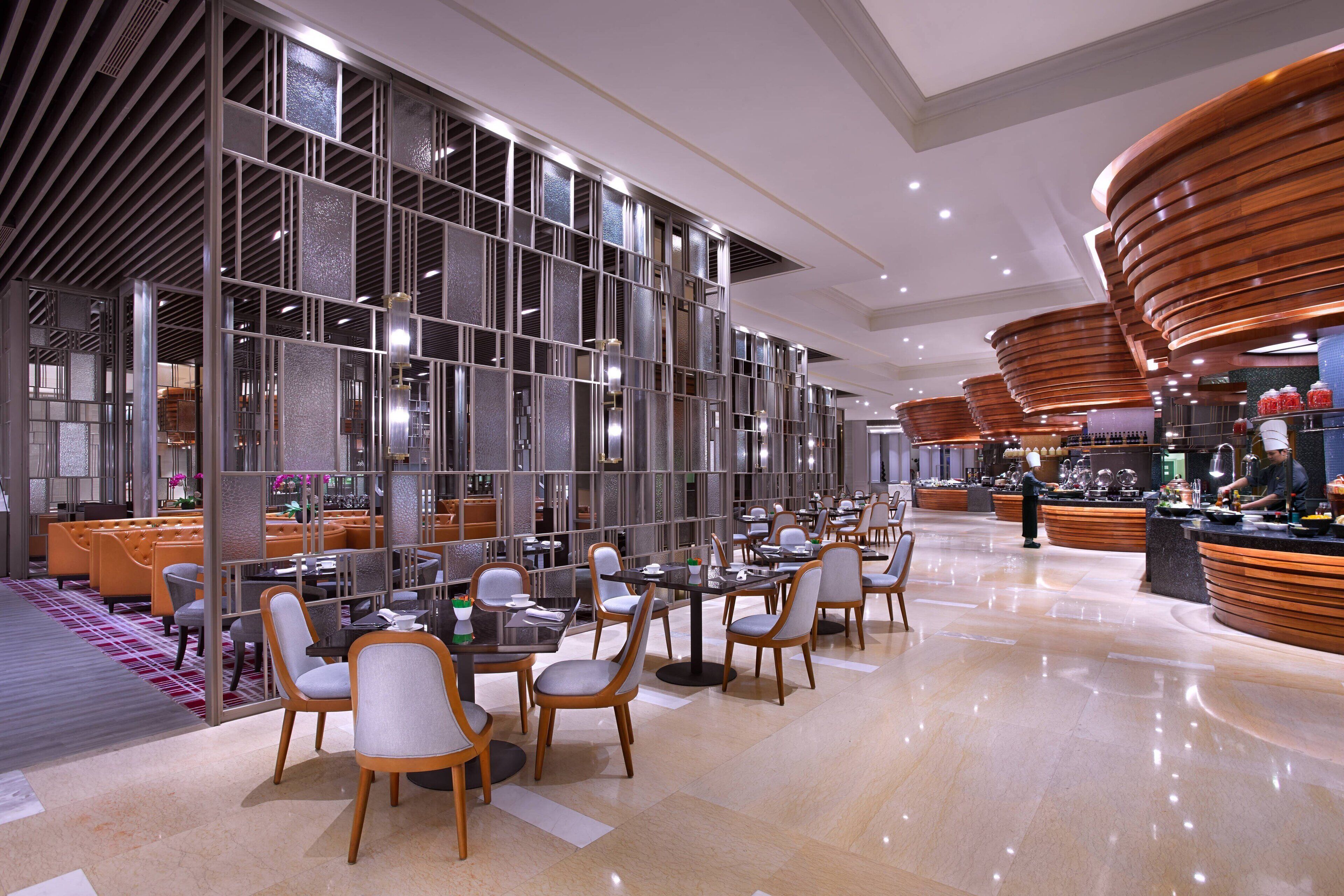 A modern hotel lobby with a spacious seating area, a reception desk, and a well-lit interior.