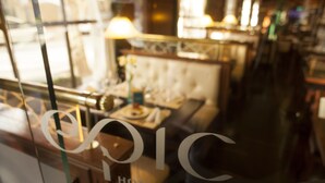 L’intérieur d’un restaurant, avec une cloison en verre sur laquelle on peut lire l’inscription « TOPIC HOTELS ».