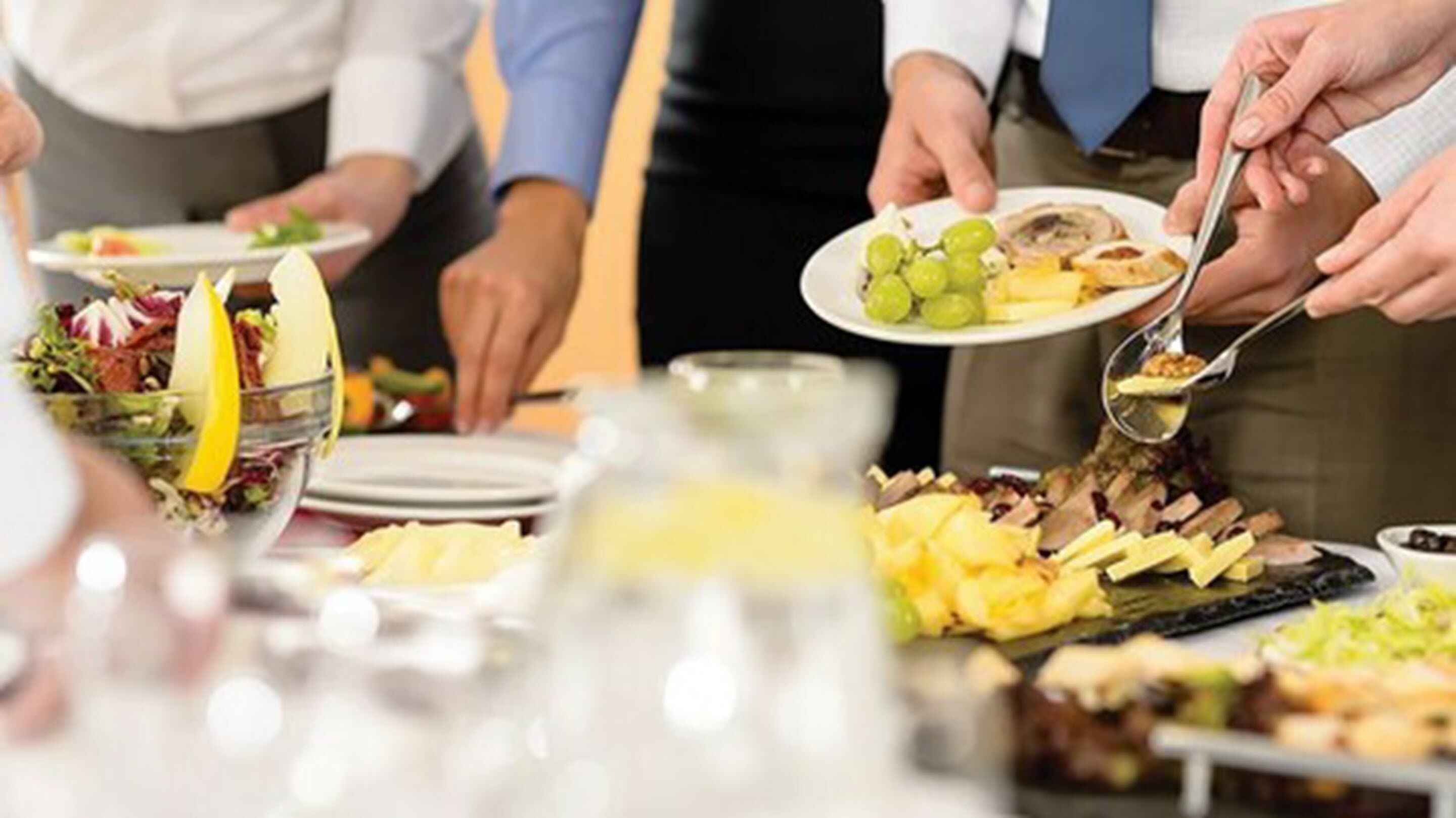 A buffet with various food items and a glass pitcher.