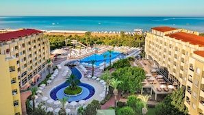 A resort with a central pool, multiple balconies, and a view of the sea. - Selectum Family Resort Side (Manavgat)
