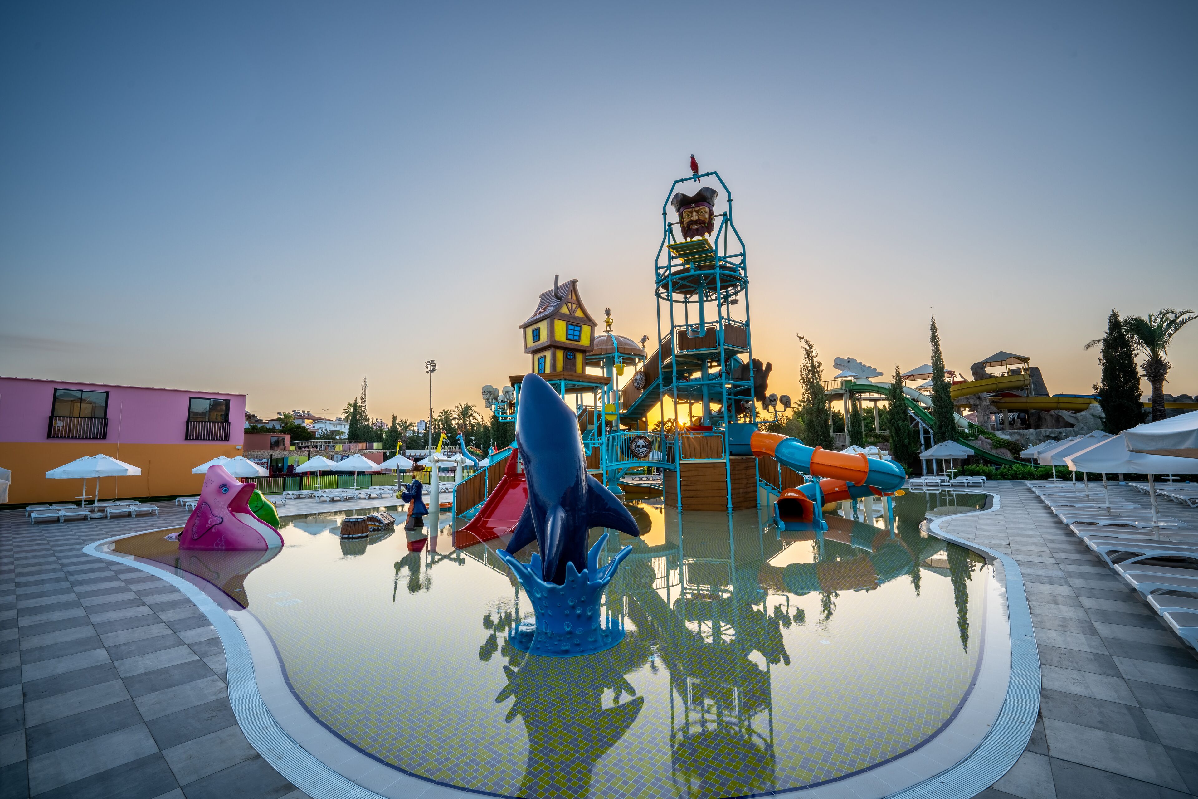 A water park with a central pool, slides, and a play structure.