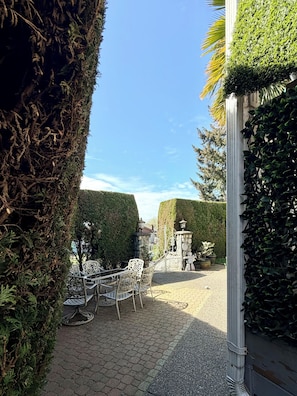 Un patio empedrado con un conjunto de asientos y una fuente decorativa.