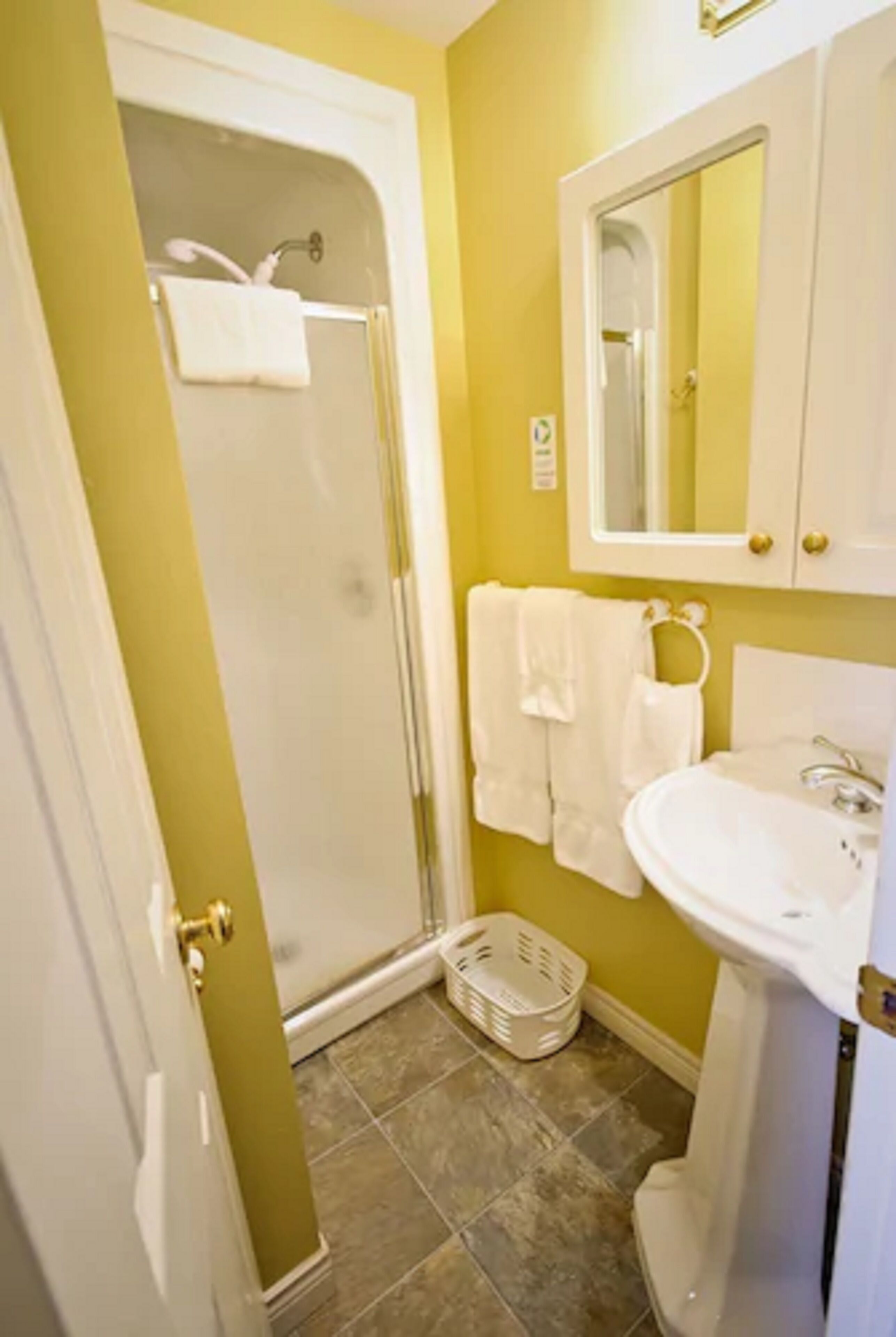 A bathroom with a shower, a sink, and a toilet.