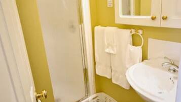 A bathroom with a shower, a sink, and a toilet.