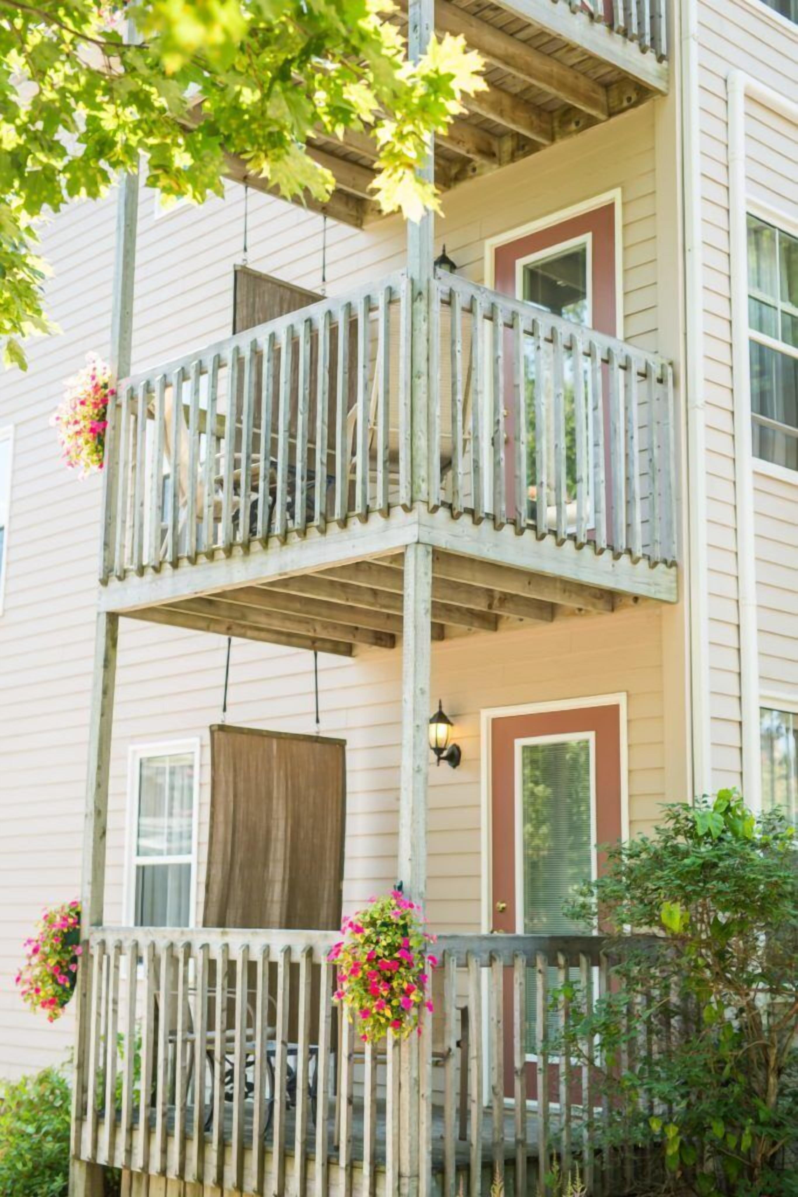 A two-story building with a wooden balcony and flower boxes.
